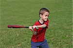 A young boy swinging the bat practicing