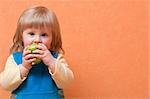 little blond girl eating green apple. Copy space at the right