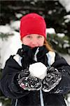 Young girl holding a snowball in her hands