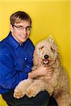 Middle-aged Caucasian man with Goldendoodle dog.