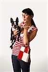 Young adult female Caucasian holding Boston Terrier.