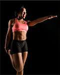 Smiling African American young adult woman standing and stretching.