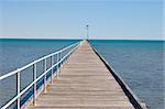 the long jetty reaches far out into the blue sea