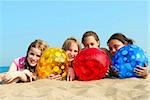 Portrait of four young girls with colorful beach balls