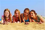 Portrait of four smiling teenage girls on a sandy beach