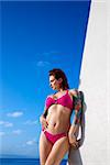 Attractive tattooed Caucasian woman in hot pink bikini posing on beach in Maui, Hawaii, USA.