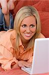 A beautiful blue eyed blond haired young woman using her laptop computer