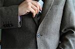 Smartly dressed business man putting a credit card into his pocket.