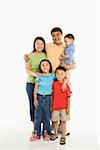 Asian parents with three children standing in front of white background.