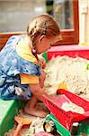 Little child playing in sandbox at home