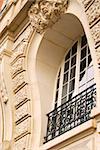 Rounded ornate window with wrought iron grid in Paris France