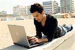 Attractive man outdoor works with a laptop