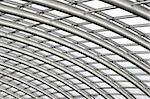 Section of the curved reinforced steel roof joists in a conservatory with glass panes in between.