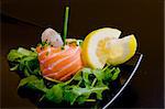 fresh raw salmon roll with a praw and rockets leaf and lemon