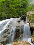 Waterfall of alpine mountain river shot with long exposure