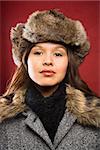 Young adult Caucasian woman wearing fur hat looking at viewer.