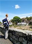 A female backpacker stops to enjoy the view at Brynrefail, Snowdonia, North Wales.