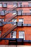 Fragment of a red brick house in Boston historical North End with iron fire escapes and balconies