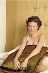 Woman in underwear sitting on a bed.