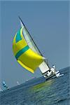 The winner of race of yachts. Yellow sail in the dark blue sea. The winner and losers.