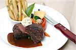 8 oz Tenderloin Steak topped with truffle butter. Served with broccoli, beans, horseradish and fries. Shallow DOF.