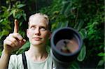 Pretty nature guide with a telescope in the rainforest
