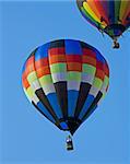 Two Hot Air Balloons Fly in a Clear Blue Sky