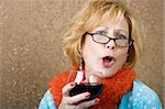 Extroverted woman with a funny expression drinking red wine