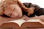 curly redhead sleeping on book