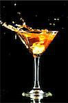 alcohol splash in martini glass on black background