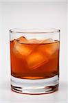 Glass of whisky with an ice on a grey background