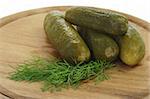 Pickled cucumbers with dill on a wooden kitchen board