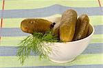 Pickled cucumbers with dill in a white bowl