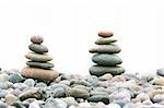 two stacks of stones over white, focus on the left one