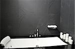 Contemporary black bathroom with geometric bathtub and candles