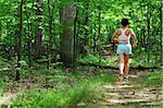 Mature woman running in forest.