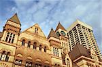 Old city hall of toronto in neo-gothic style near a modern skyscraper under the sunset light