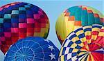 Colorful hot air balloons in various stages of inflation.