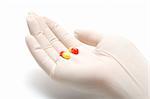 Helping hand in latex glove giving pills, isolated, on white background