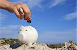 A woman hand putting a button on a piggy bank symbolizing a bankruptcy