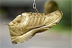 Golden running shoes hanging on the chain