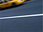A New York yellow cab in motion on the street.