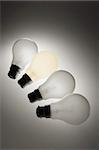 Four Light Bulbs on Grey Background