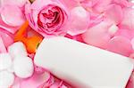 Blank skin care lotion with rose petals and cotton swabs