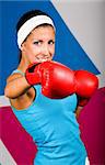 Attractive young woman with red boxing gloves in gym