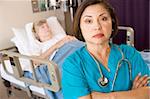 Doctor Standing With Arms Crossed In Patients Room