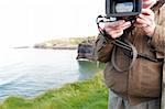 a cameraman filming on the cliff edge in ballybunion ireland