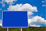 Blank billboard on blue sky in a mountainous area, just add your text