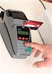 A retailer, salesman or customer using an eft pos machine to make a transaction payment.  Focus to hand and machine only.