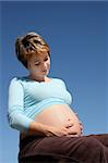 A pregnant young woman sitting outdoors